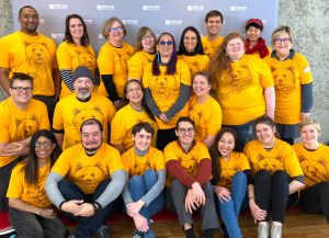 2020 group photo of Portland Film Festival Volunteers n yellow Festival T-shirts in front of a backdrop.
