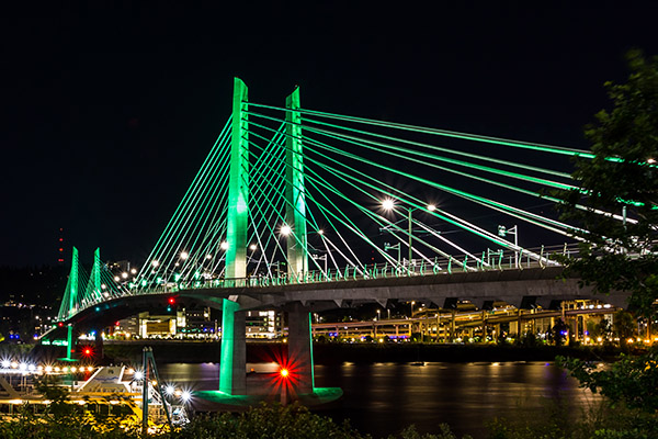 Night photo of the Tilikum Crossing located near OHSU's Waterfront Campus in SW Portland. We encourage everyone attending to us Tri-Met.