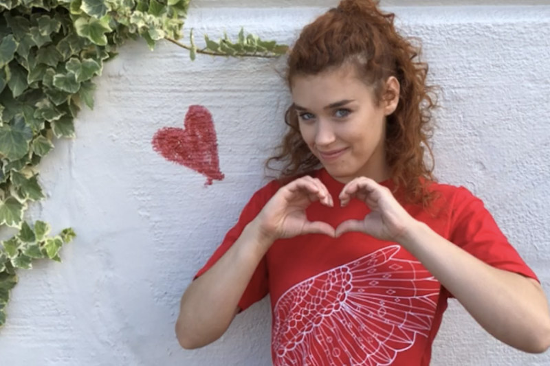 Photo of Model from Taylor Horris Modeling Agency wearing Portland merchandise from 2018, the year of the owl, flashing a heart symbol.